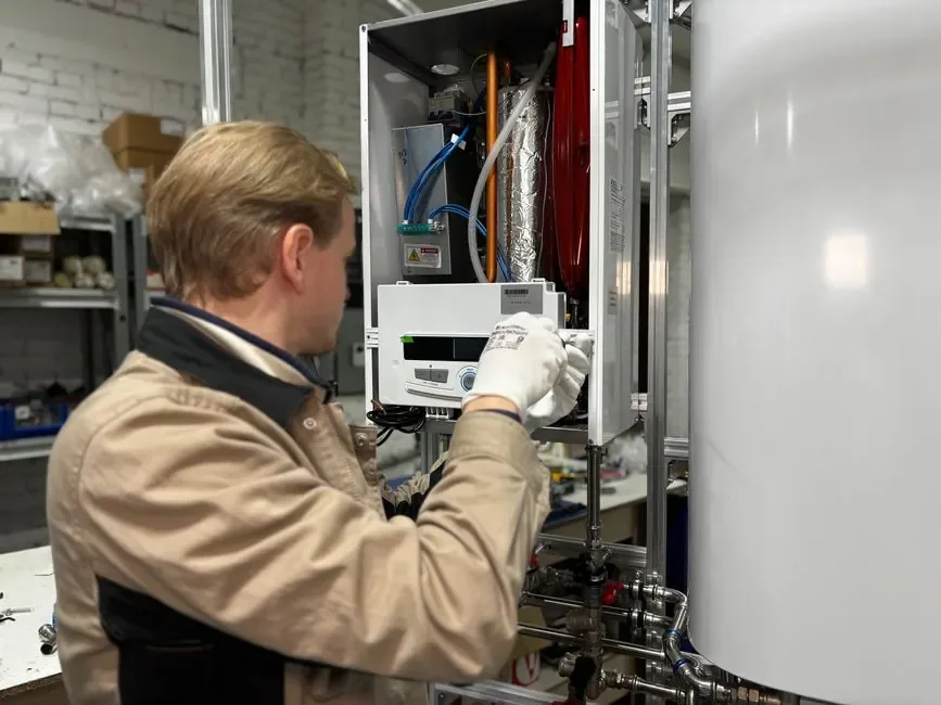 Plumber servicing a wall-mounted tankless water heater